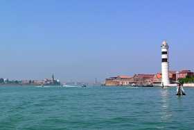 A view of Murano and its lighthouse, with Isola di San Michele and Venice on the horizon